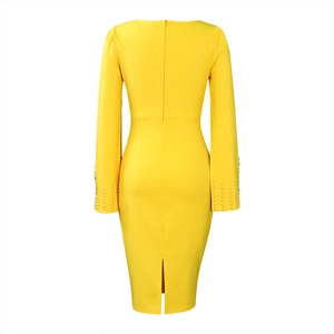 Détail du dos d'une robe jaune avec fermeture éclair et perles brodées sur les manches