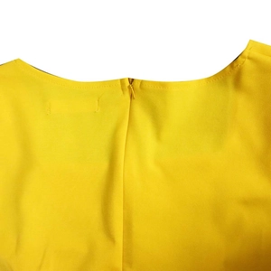 Détail du col arrière d'une robe jaune avec fermeture éclair invisible et couture