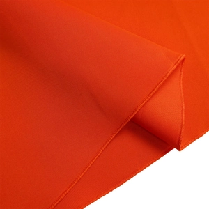 Detail of orange double-layered ruffled sleeve fabric with precise twill texture and stitching