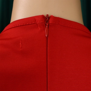 Detail of red V-neck dress featuring a seamless invisible zipper and fine knit texture