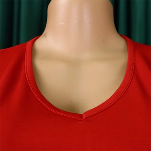 Close-up of the V-neckline on a red pencil dress with detailed stitching and fine texture