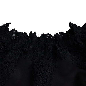 Detailed view of intricate black lace neckline with elegant hollow-out crochet patterns