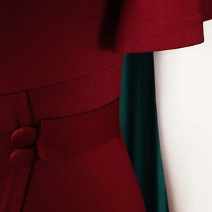 Detail of wine red dress with decorative waist buttons and ruffled sleeve craftsmanship