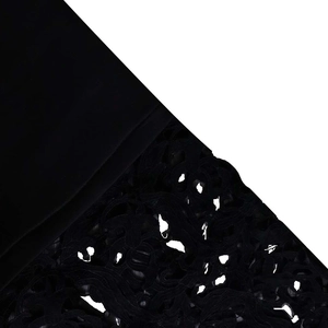 Close-up of black dress featuring intricate lace patchwork and premium fabric texture
