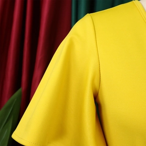Close-up of bright yellow dress showing the ruffle sleeve detail and twill knit texture