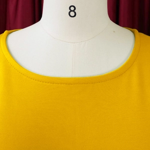 Detail of round neckline on yellow summer dress showing fine mesh knit texture