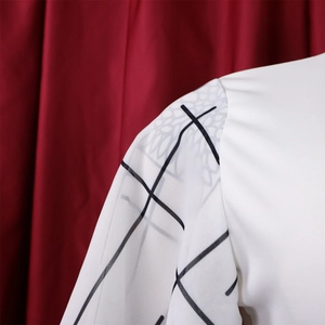 Detail of white blouse featuring black geometric lines and sheer chiffon sleeves texture