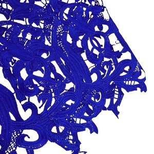 Macro shot of bright blue lace fabric with detailed floral vine embroidery patterns