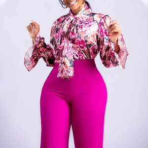 Detail der floralen Satin-Schluppenbluse kombiniert mit fuchsiafarbener High-Waist-Hose