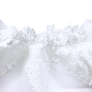 Close-up of white lace embroidery detailing on off-shoulder lantern sleeve evening dress