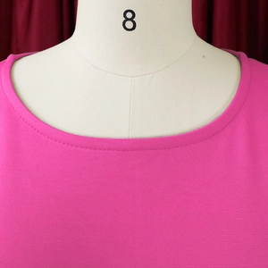 Detail shot of rose red knit top showing fine texture and neat neckline stitching