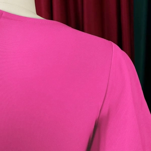 Close-up of the peach pink round neck and stitching on this professional dress