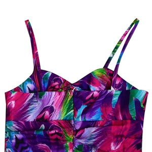 Detail of vibrant floral print dress featuring thin straps and pleated chest design