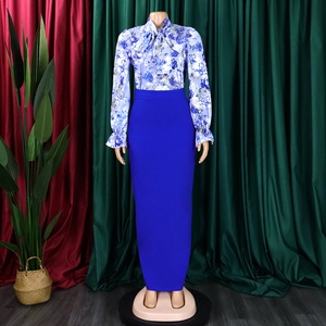 Dettaglio della camicia floreale con fiocco e gonna lunga a vita alta blu reale