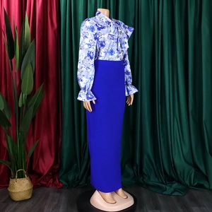 Dettaglio camicia floreale con fiocco al collo e gonna lunga blu reale a due pezzi