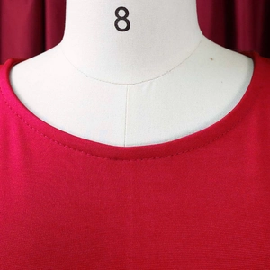 Detailed close-up of double-stitched neckline on a professional red pencil dress