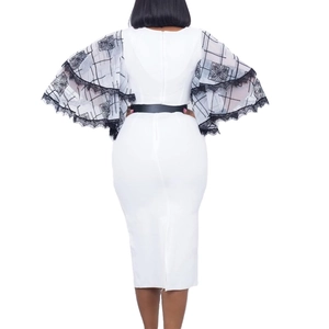Detail of flared sleeves with black and white plaid patterns and lace trim on white dress
