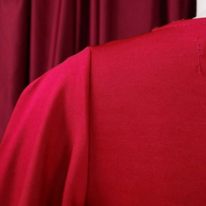 Close-up detail of the ruffled sleeve and stitching on the red bodycon dress