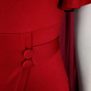 Detail of red business dress featuring retro waist design and elegant fabric buttons