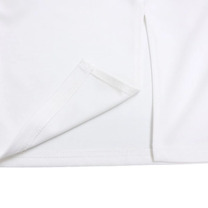 Detail of the high-density white fabric showing fine stitching and side slit on the dress