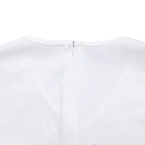 Detail of white pencil dress back featuring a V-neck and a matching invisible zipper