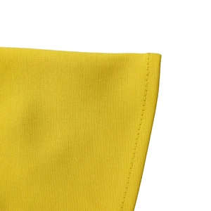 Macro shot of bright yellow knitted fabric texture and fine stitching on the dress