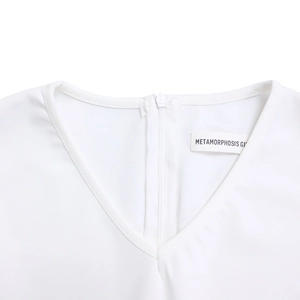 Detail view of the V-neckline and invisible back zipper on a white pencil dress