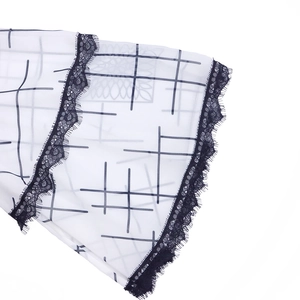 Detail of white checkered chiffon sleeve with delicate black eyelash lace trim