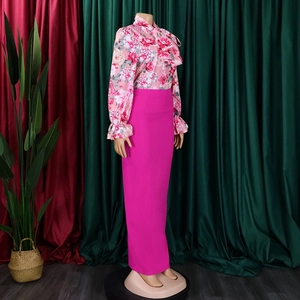 Dettaglio camicia floreale in chiffon con fiocco e gonna fucsia a vita alta