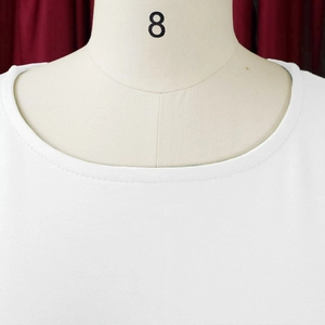 Close-up of white crew neck top showing high-quality double-needle stitching on the neckline