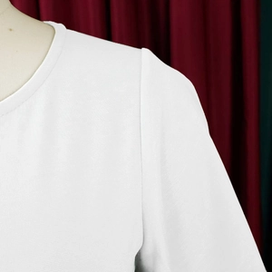 Close-up of white round neck top showing waffle knit texture and shoulder stitching detail
