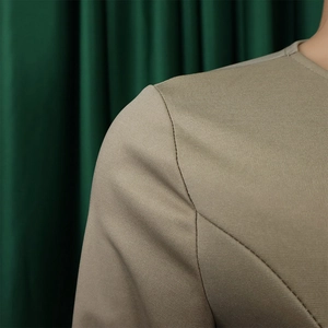 Close-up of khaki structured blazer shoulder with premium twill fabric and fine stitching