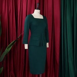 Detalle de elegante traje verde oscuro con cuello cuadrado y falda de tubo