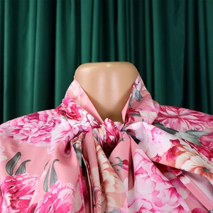 Dettaglio della camicetta a fiori in chiffon con fiocco al collo e motivi di rose