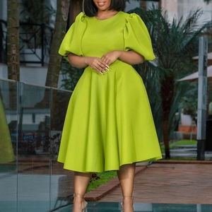 Elegant bright green A-line midi dress with puff sleeves and round neck in garden setting