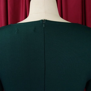 Detalle del vestido verde oscuro con cremallera invisible y textura de la tela