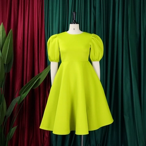 Détail d'une robe trapèze jaune vif avec manches bouffantes et taille cintrée sur un mannequin