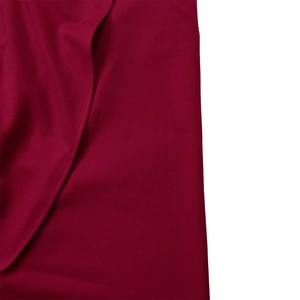 Detailed macro view of wine red dress fabric showing fine texture and quality stitching