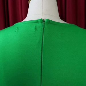 Close-up of invisible back zipper and stitching detail on green ruffle dress