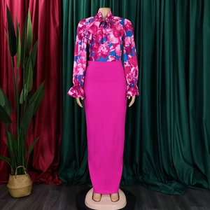 Dettaglio della camicia floreale magenta con fiocco oversize e gonna lunga coordinata