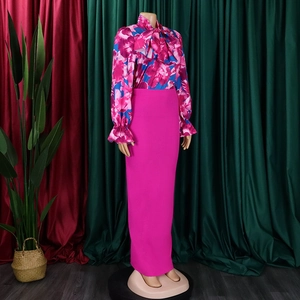 Dettaglio camicetta in chiffon floreale con fiocco e gonna lunga fucsia aderente