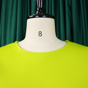 Gros plan du col rond et du tissu en maille lisse vert lime de la robe élégante