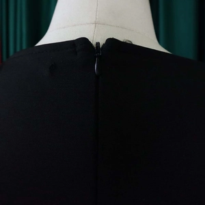 Detail of professional black dress showing round neck and hidden back zipper closure
