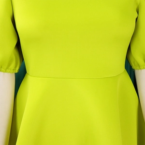 Détail de la robe vert citron montrant la couture taille haute et les poignets plissés