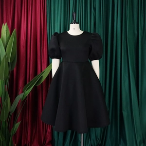 Détail des manches bouffantes noires et du col rond élégant sur la robe de soirée vintage