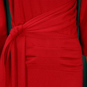 Detailed close-up of red fitted dress with waist tie knot and elegant ruched texture