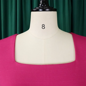 Detalle de un elegante vestido de punto magenta con escote cuadrado y textura fina