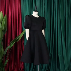 Vue détaillée d'une robe noire ligne A avec manches bouffantes et col rond classique
