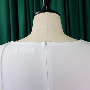 Détail du dos de la robe blanche avec fermeture éclair invisible et texture en maille fine