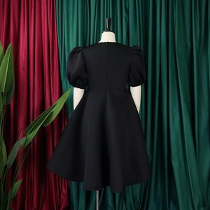 Détail du dos de la robe noire à manches bouffantes avec fermeture éclair invisible et coupe A